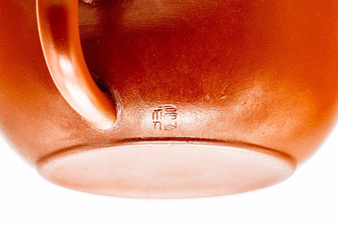 Close-up of the glossy red shudei surface and pouring spout.