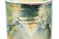 Close-up of the brown-and-green drip glaze running down the cup's body.