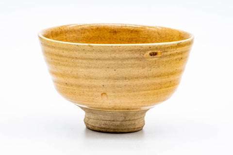 Ido-shaped Ki-Seto chawan with a deep yellow crazed glaze, viewed from the front, showing the spiralling 'rokurome' throwing lines and flared rim.