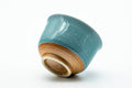 The cup tipped to show its unglazed foot.