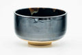 Dark drip-glazed chawan, front view showing the glossy black glaze with golden-brown drips