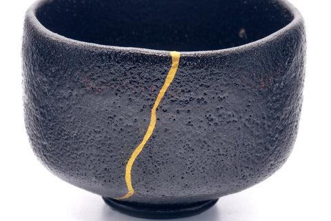 Side view highlighting the gold kintsugi seam down the bowl.