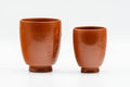 Japanese Teacups - Pair of Smooth Red Shudei Tokoname-yaki Meoto Yunomi with Wooden Box - front view of the pair showing the larger and smaller cups