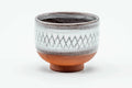 Single white guinomi teacup with an incised diamond lattice pattern and exposed red-clay foot, front view.