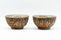 Pair of small teacups, front view showing the carved brown clay exterior