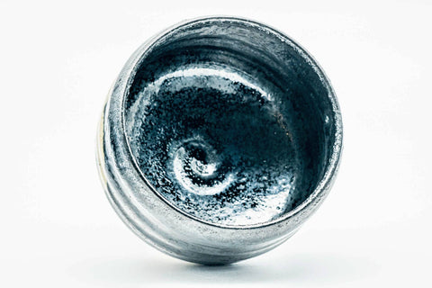 Overhead view looking into the swirled dark metallic interior of the chawan