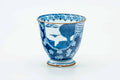 Blue-and-white Arita-yaki teacup decorated with floral, geometric, and landscape motifs, front view.