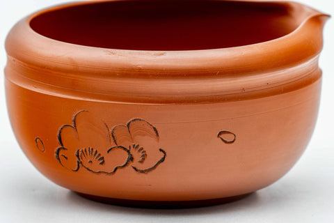 Close-up of the engraved floral design carved into the red clay body of the katakuchi.