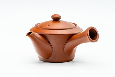 Side profile of the teapot with the spout to the left and handle to the right.
