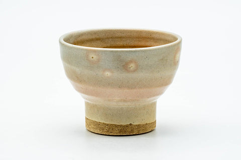 Front view of the beige Hagi teacup showing its tall foot and warm glaze.