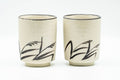 Japanese Teacups - Pair of Beige Long Grass Yunomi - 110ml - the pair of cups side by side, front view with the black long-grass brushwork