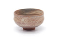 Pink-white hakeme chawan, three-quarter view emphasising the carved comb pattern around the lower body