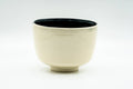 Kyo-yaki hantsutsu chawan matcha bowl, front view, cylindrical cream-beige exterior with jet-black interior glaze