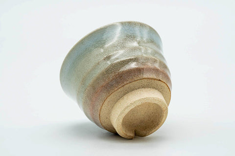 Teacup tilted to show the lower body and unglazed foot.