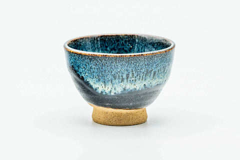 Single teal-blue drip-glazed guinomi teacup on a pale foot, front view.