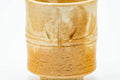 Close-up of a single cup showing the engraved bamboo design and drip glaze.