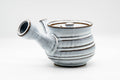 Side profile of the kyusu, spout to the left and side handle to the right, horizontal ribbed glaze.