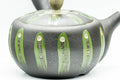 Close-up of the green geometric striped glaze on the teapot's black body.