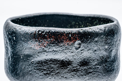 Close-up of the textured black raku glaze and rim