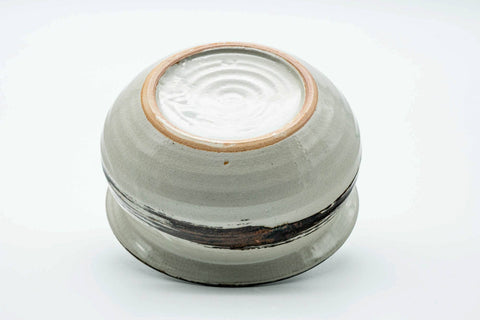 Bowl tilted to show the unglazed foot ring and underside.