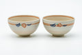 The paired cups side by side, showing the orange-brown striped bands near the rim.