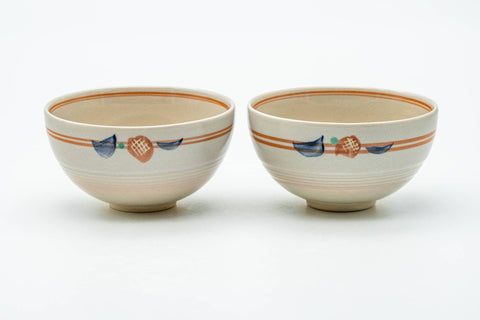 The paired cups side by side, showing the orange-brown striped bands near the rim.