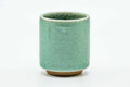 Side view of the celadon teacup, showing the crackled green glaze.