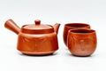 Bamboo-engraved Tokoname-yaki tea set grouped together — red shudei clay kyusu teapot with two matching yunomi teacups
