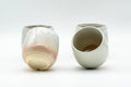 Japanese Teacups - Set of 4 Tsubaki Kiln Hagi-yaki Yunomi - 90ml - one cup upright beside another tilted to show the glazed interior