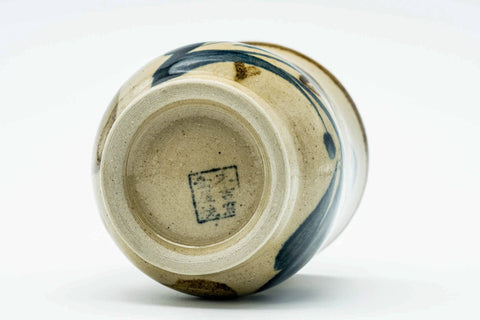Underside close-up of the cup showing the foot and maker's mark, with the lid beside it.