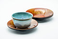 Japanese Chataku - Set of 3 Abstract Kara-nuri Red Lacquered Tea Saucers - a teal teacup resting on a mottled orange-red lacquer saucer with others, shown for scale