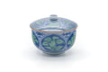 Front view of the lidded porcelain teacup showing the blue-green leaf motif.