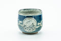 The cup from another side, showing a circular medallion motif.