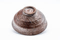 The tenmoku-gata chawan inverted to show its small foot and unglazed base.