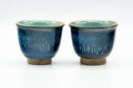 Pair of deep-blue Agano-yaki yunomi with turquoise drip glaze, side by side, front view.