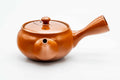 Rear three-quarter view of the red kyusu showing the side handle.