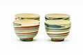 The four nerikomi teacups grouped together showing their layered marbled stripe pattern.