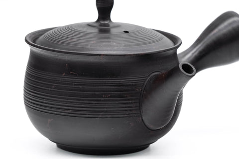 Spiraling benishibori Tokoname teapot, angled view of the ribbed black body