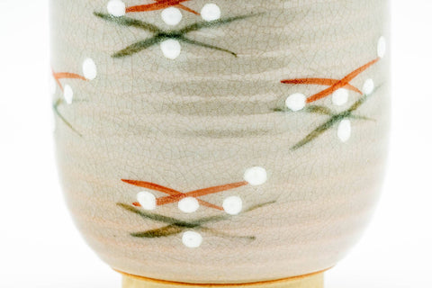 Close-up of the painted floral sprig decoration on the cup's surface.