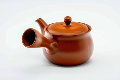 Rear three-quarter view of the round red kyusu showing the side handle.