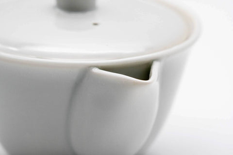 Close-up of the white porcelain glaze where the lid meets the body and spout.