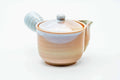 Pink-beige Hagi-yaki side-handle kyusu with pale drip glaze, three-quarter view with lid on