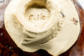 Close-up of the katakuchi underside foot with a maker's mark in the pale clay