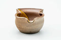 Front view of the ash-glazed katakuchi showing its wavy rim and dark amber glazed interior.
