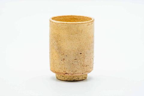 Side view of the teacup, showing the mottled beige-cream glaze.