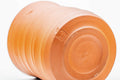 Teacup tilted to show the spiraling orange clay exterior and foot.
