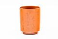 Close-up of a single cup inscribed with Japanese calligraphy.