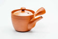 Small red shudei Tokoname-yaki side-handle kyusu, lid on, shown from the side.
