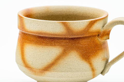 Close-up of one teacup showing the reddish-brown hidasuki straw marks on the pale Bizen clay.