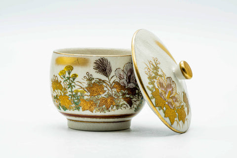 The cup with the lid beside it, showing the floral decoration and interior.